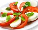 An appetizing caprese salad with fresh tomatoes, mozzarella and basil. 